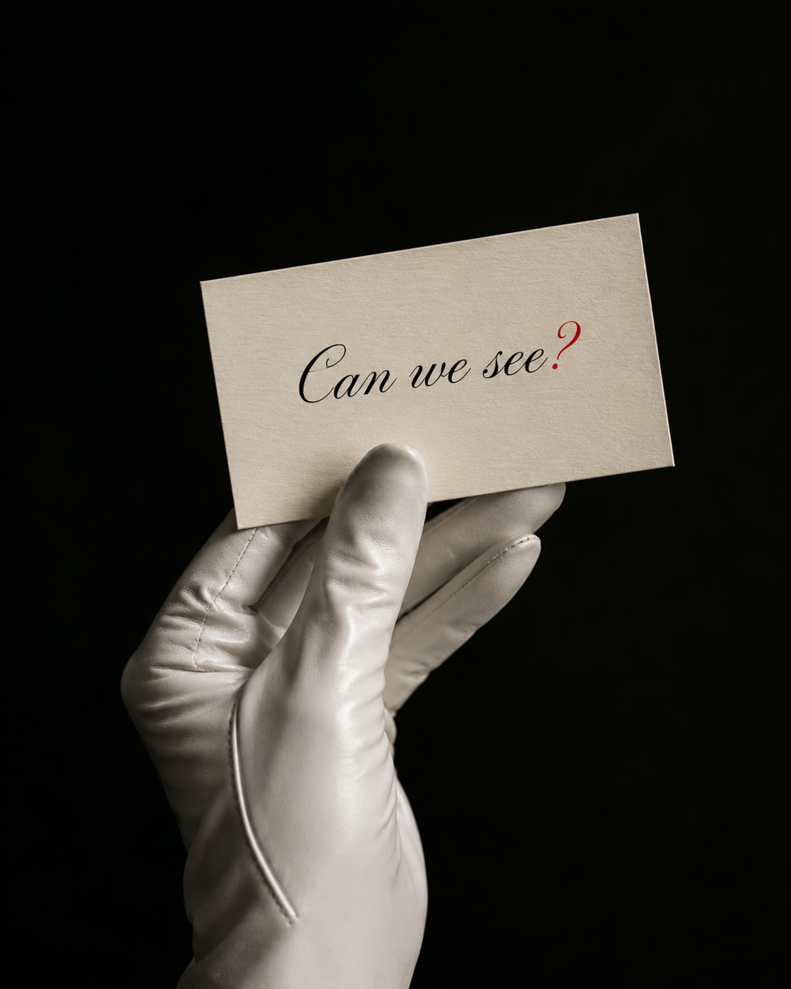 A white-gloved hand holding a card that reads can we see