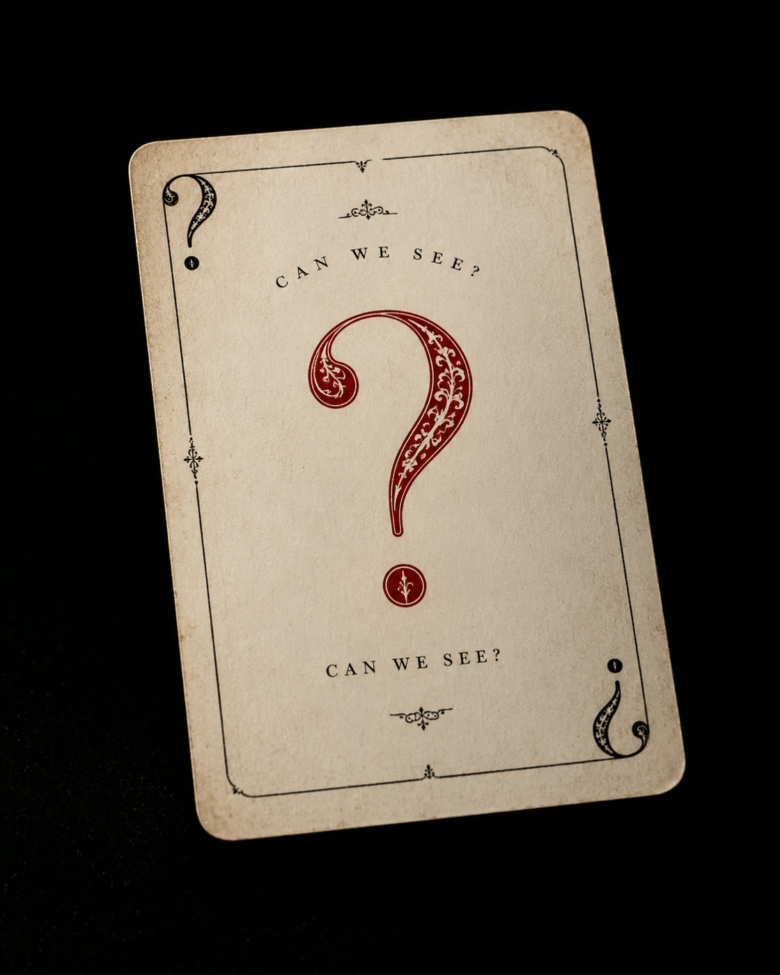 A vintage playing card with an ornate red question mark