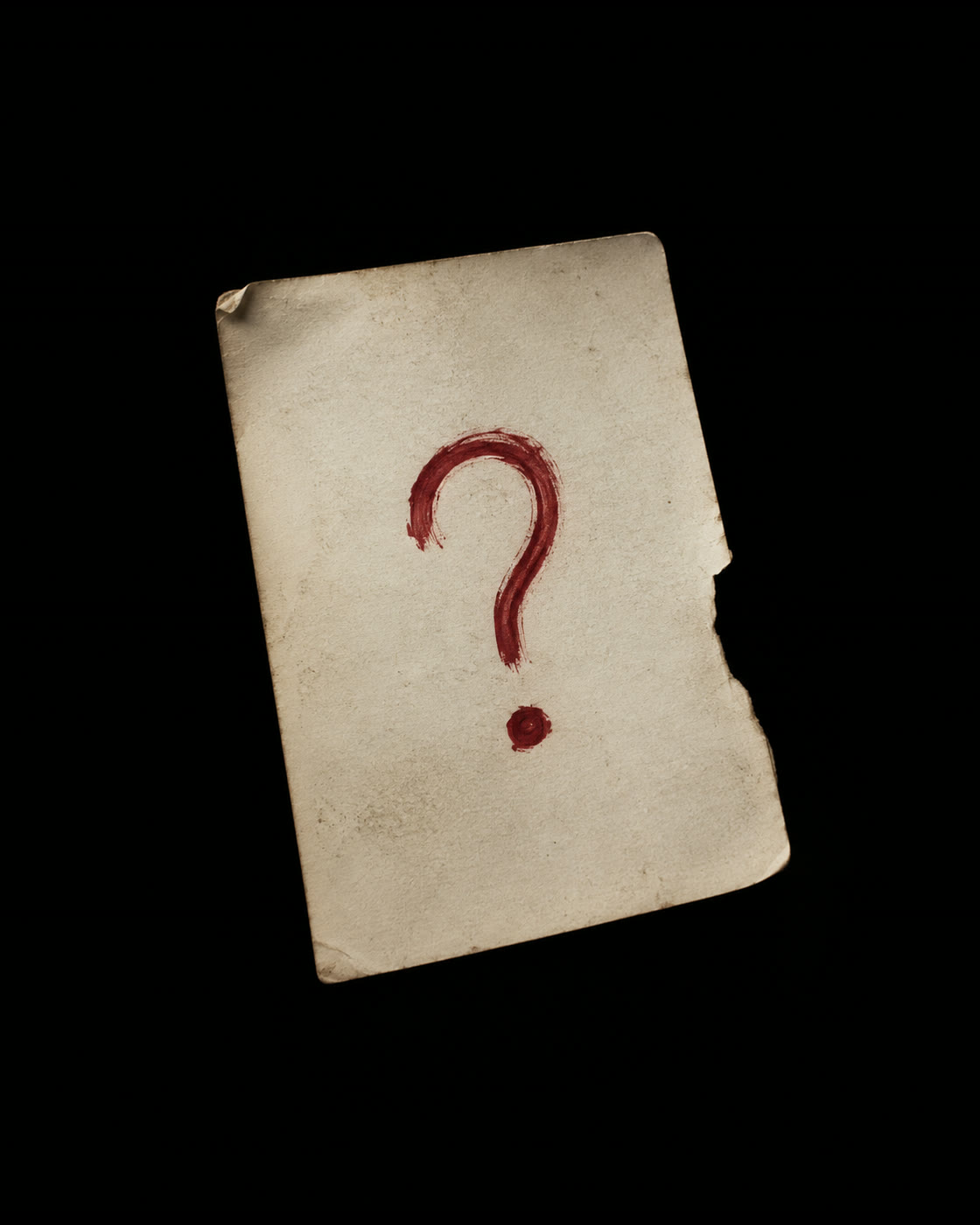 A hand-painted red question mark on aged paper